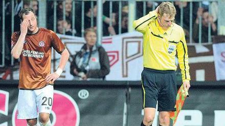 Dieser Wurf tut weh. Assistent Thorsten Schiffner (r.) hat einen vollen Bierbecher in den Nacken bekommen. 