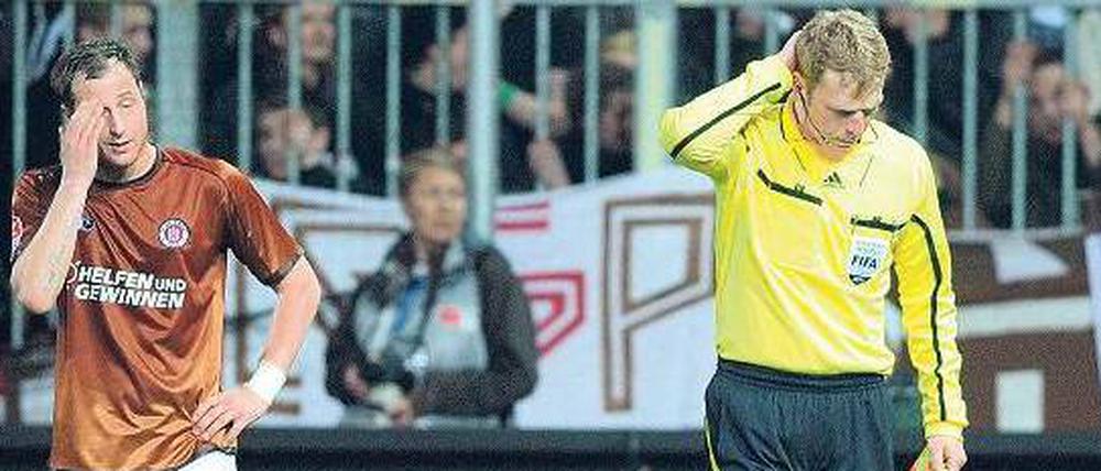 Dieser Wurf tut weh. Assistent Thorsten Schiffner (r.) hat einen vollen Bierbecher in den Nacken bekommen.