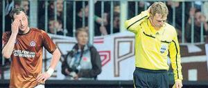 Dieser Wurf tut weh. Assistent Thorsten Schiffner (r.) hat einen vollen Bierbecher in den Nacken bekommen.