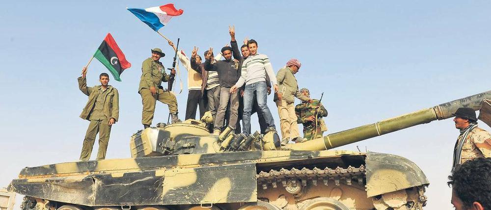 Farben der Rebellen. Aufständische schwenken auf einem von den Gaddafi-Truppen erbeuteten Panzer die französische Flagge und ihre Revolutionsfahne. 