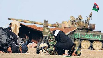 Beten für den Erfolg. Libysche Rebellen, schlecht trainiert und mangelhaft ausgestattet, an der Frontlinie nahe der Stadt Brega. 