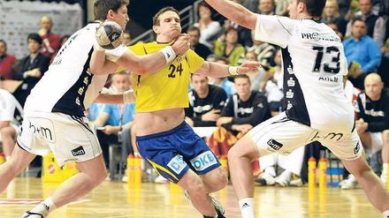 Bis hierhin und nicht weiter. Bartlomiej Jaszka (m.) wird von der Kieler Deckung gestoppt, die Füchse vom THW.