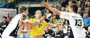 Bis hierhin und nicht weiter. Bartlomiej Jaszka (m.) wird von der Kieler Deckung gestoppt, die Füchse vom THW. 