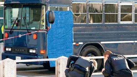 Am Tatort. Polizisten suchen vor dem US-Militärbus nach Spuren. Foto: dapd