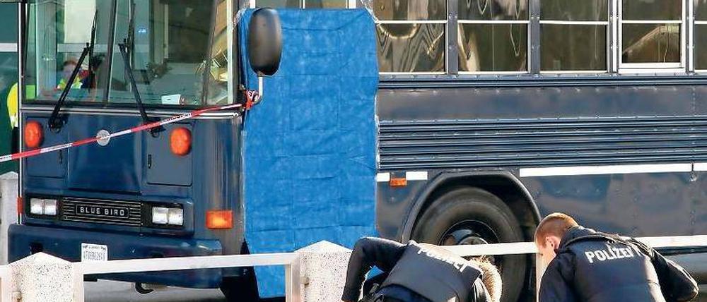 Am Tatort. Polizisten suchen vor dem US-Militärbus nach Spuren. Foto: dapd