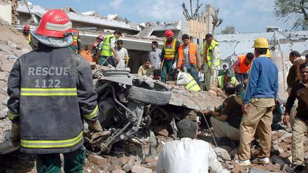 Rettungskräfte versuchen, Tote und Verletzte aus den teilweise zerstörten Häusern zu bergen.