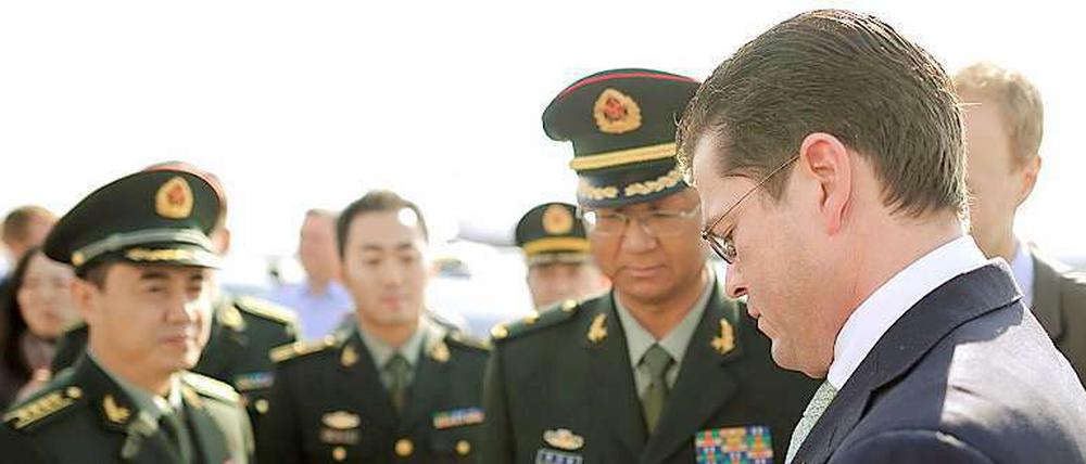 Autogramm. Guttenberg signiert vor seiner Abreise aus Peking Porträtfotos. 