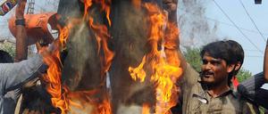 Idol in Flammen. Enttäuschte Fans verbrennen eine Puppe von Kricket-Kapitän Butt, dem Betrug vorgeworfen wird.