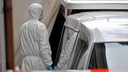 Schreckliches Ende eines Familiendramas: Ein Beamter steht am Mittwochmorgen neben dem Leichenwagen im niedersächsischen Delligsen.