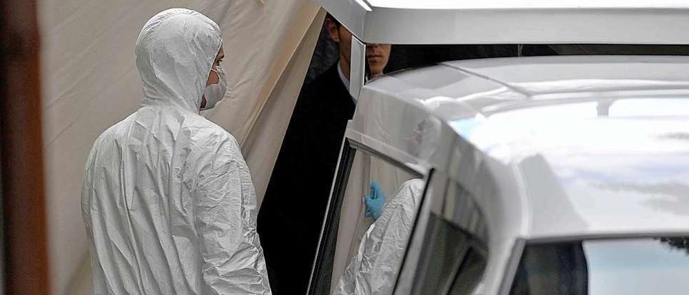 Schreckliches Ende eines Familiendramas: Ein Beamter steht am Mittwochmorgen neben dem Leichenwagen im niedersächsischen Delligsen.