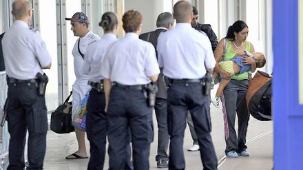Von Polizisten überwacht erreicht die erste Gruppe "freiwilliger Roma-Rückkehrer" am Donnerstagmorgen den Saint-Exupery Flughafen in Lyon.