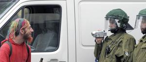 Polizisten nehmen auf der Frankfurter Allee bei einer Demo gegen rechte Gewalt einen Teilnehmer mit einer Videokamera auf.