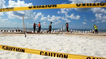 In Orange Beach, Alabama, befestigen Arbeiter Barrieren, die das Öl aufsaugen sollen, wenn es an der Küste angeschwemmt wird.