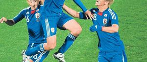 Kleine Japaner? Mag sein, aber bei seinem Torjubel schraubt sich Yasuhito Endo enorm in die Höhe (oben). Sein Teamkollege Daisuke Matsui wird gleich von zwei Dänen stark bedrängt. Fotos: AFP, dpa