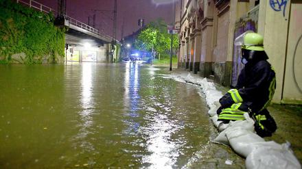 Ein Feuerwehrmann im Ortsteil Bockenheim von Frankfurt am Main auf Sandsäcken, die Keller und Einfahrten von Häusern vor den Wassermassen schützen sollen.