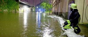 Ein Feuerwehrmann im Ortsteil Bockenheim von Frankfurt am Main auf Sandsäcken, die Keller und Einfahrten von Häusern vor den Wassermassen schützen sollen.