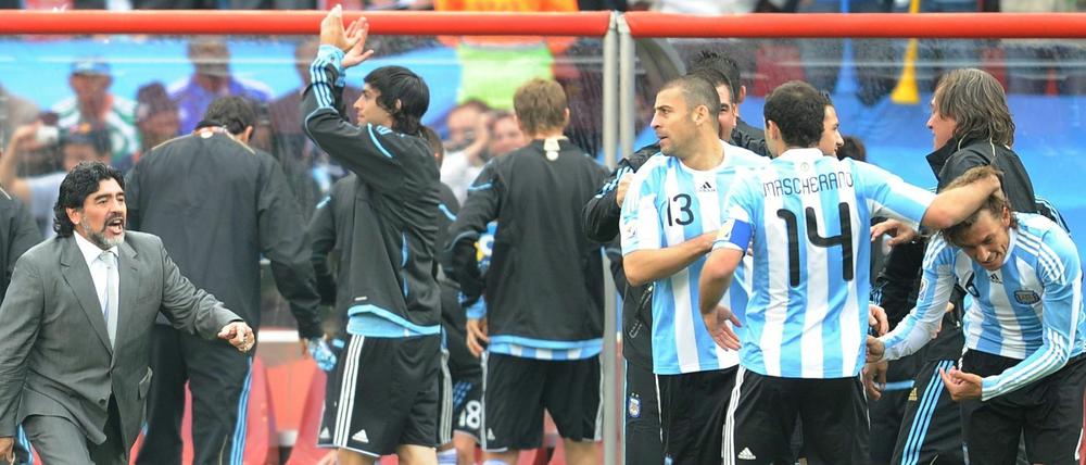 Diego Maradona und seine Argentinier schlagen in Ihrem ersten Gruppenspiel Nigeria mit 1:0. Walter Samuel und Javier Mascherano tätscheln den Torschützen, Gabriel Heinze. Auch der Coach freut sich mit.