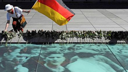 Ein Mitglied des SPD-Ortsverbands Berlin-Mitte legt vor dem Bundesfinanzministerium an der Gedenkstätte für den Volksaufstand vom 17. Juni 1953 eine Rose nieder