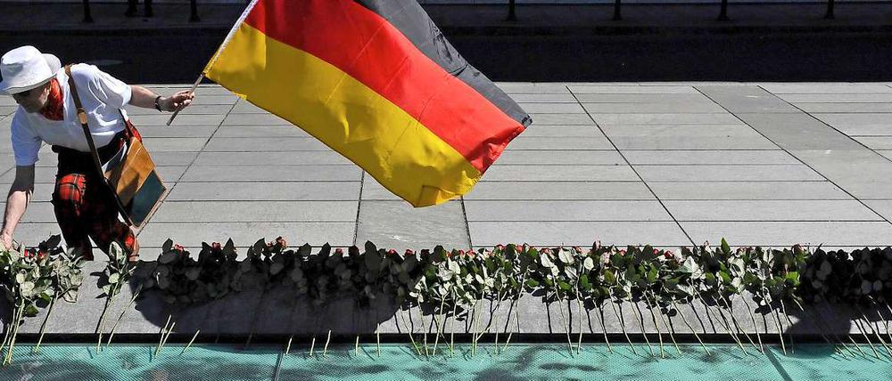 Ein Mitglied des SPD-Ortsverbands Berlin-Mitte legt vor dem Bundesfinanzministerium an der Gedenkstätte für den Volksaufstand vom 17. Juni 1953 eine Rose nieder