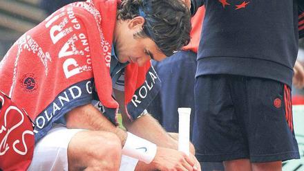 Ein Schirm für den Champ. Roger Federer scheint sich hier verstecken zu wollen. Paris verlässt der Schweizer in diesem Jahr ohne den French-Open-Titel. 