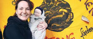 Hebamme mit Gehilfin. Die Puppe Emma nimmt Christiane Klimisch oft mit zu Patientinnen. Im Hintergrund ist ihr Banner für die Demonstration zu sehen.