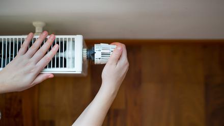 Hand of young woman changing the temperature on the radiator by temperature controller