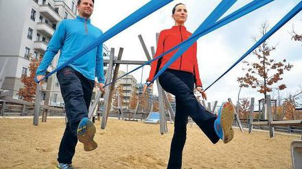 Ziehen und strecken. Die Personal Trainer Andrea Göhre und Sven Röhr zeigen, wie man das Theraband nach hinten dehnt und dabei ein Bein nach vorn führt. Eine Übung fürs Gleichgewicht. 