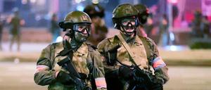 Bewaffnete Polizisten stehen während eines Massenprotests in Belarus auf der Straße.