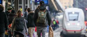 Fahrgäste warten am Stuttgarter Hauptbahnhof auf die Einfahrt eines ICE-Zuges mit Fahrtziel München.