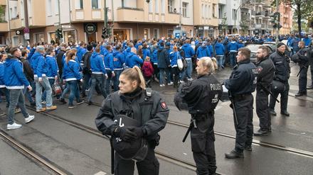 Eine Stadt im Fußball-Wahn. Polizeibeamte beobachten am Boxhagener Platz den Abzug von Hertha-Fans auf ihrem Weg zum Fußballspiel gegen Union in Köpenick. 