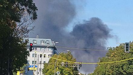 Eine Rauchwolke ist über Neukölln zu sehen. Das Feuer ist auf einem Schrottplatz ausgebrochen.