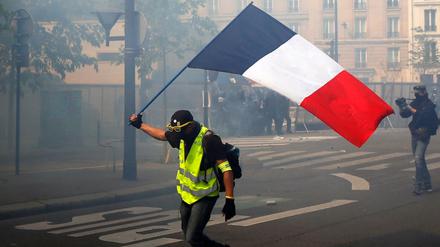 Ein Demonstrant der "Gelbwesten" schwenkt eine französische Flagge während einer Demonstration am Internationalen Tag der Arbeit.