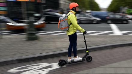 Auf dem Radweg geht's doch auch. Eine E-Scooterin in Brüssel.