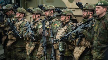 Soldaten der Bundeswehr stehen bei einer Übung im Gelände.