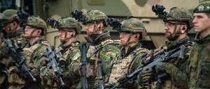 Soldaten der Bundeswehr stehen bei einer Übung im Gelände.