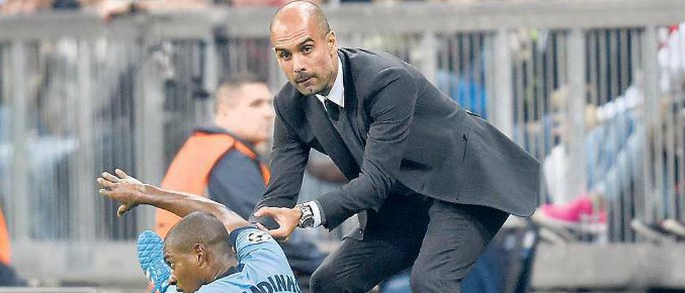 Aufbauhilfe. Guardiola soll Manchester City zu neuem Glanz führen, hier hilft er schon einmal Fernandinho in der Champions League auf die Beine. Foto: Imago/MIS