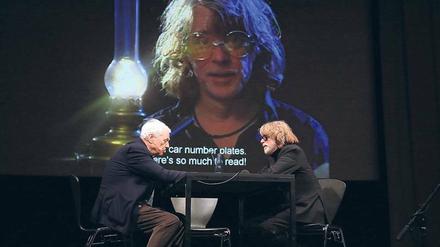 Zwei Freunde auf ihren vier Buchstaben. Alexander Kluge (links) und Helge Schneider im HKW. Im Hintergrund: Szene aus dem Film "Ich bin eine Leseratte" mit Schneider als Walter Wöhler.
