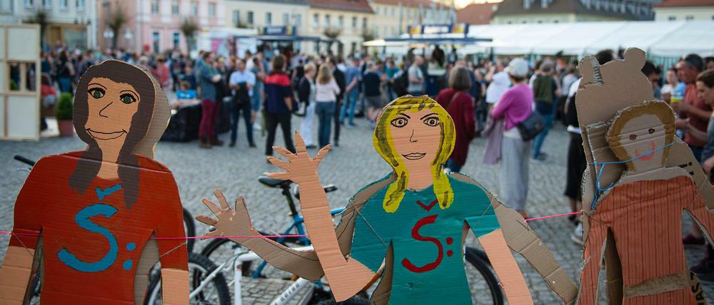 Bemalte Figuren stehen während der Eröffnung "Ostritzer Friedensfest" als Gegenveranstaltung zum Festival "Schild und Schwert" auf dem Markt.