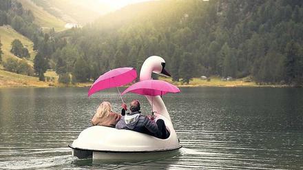 Da geht was. Astrid und Rolf lassen sich auch nicht vom Regen und pinken Schirmen von der Fahrt im Schwanen-Tretboot abhalten.