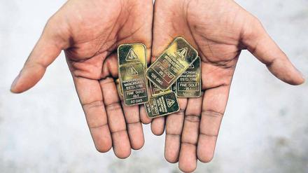 Mit vollen Händen. Nachdem die US-Notenbank Fed die Straffung der Geldpolitik verschoben hat, verteuert sich das Edelmetall wieder. Foto: Reuters/Danish Siddiqui