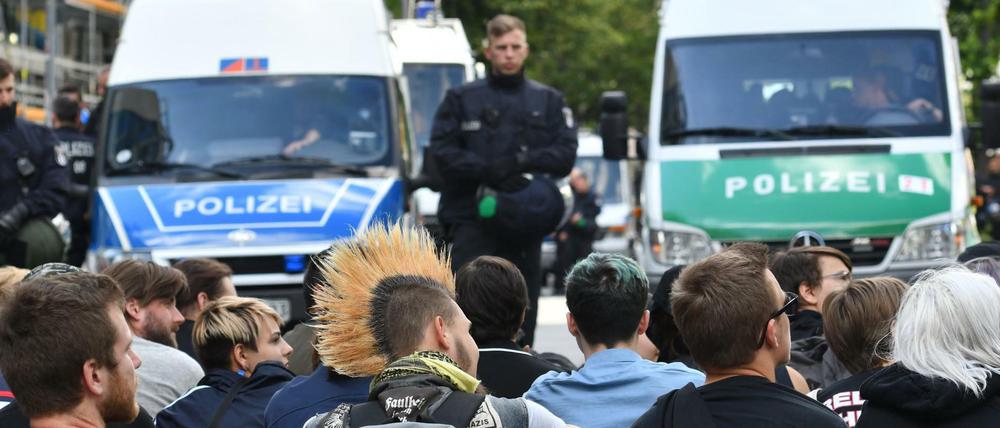 Menschen sitzen auf der Straße und verhindern so den Weiterzug der «Identitären Bewegung». 