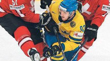 Schweizer Sandwich. Ryan Gardner (l.) und Severin Blindenbacher (r.) umrahmen den Schweden Gabriel Landeskog. Foto: AFP
