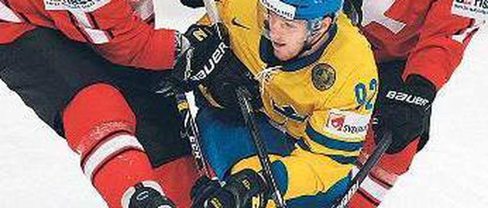 Schweizer Sandwich. Ryan Gardner (l.) und Severin Blindenbacher (r.) umrahmen den Schweden Gabriel Landeskog. Foto: AFP