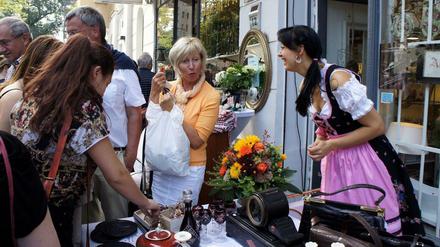 Auf der Antikmeile Suarezstraße kleiden sich auch einige Händler wie die Dame rechts passend nostalgisch.