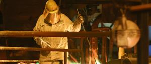 Ein Mitarbeiter von Aurubis kontrolliert einen Ofen, durch den Kupfer-Gießwalzdraht läuft. 