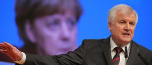 Der bayerische Ministerpräsident Horst Seehofer (CSU) spricht am 15.12.2015 beim CDU-Bundesparteitag in Karlsruhe (Baden-Württemberg). Auf der Videoleinwand ist Bundeskanzlerin Angela Merkel (CDU) zu sehen. 