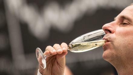 Ein Börsenhändler trinkt am 30.12.2015 in Frankfurt am Main (Hessen) im Handelssaal der Börse ein Glas Sekt vor der Dax-Kurve. Am letzten Handelstag eines insgesamt erfreulichen Börsenjahres 2015 haben die deutschen Aktienkurse etwas nachgegeben. 