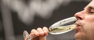 Ein Börsenhändler trinkt am 30.12.2015 in Frankfurt am Main (Hessen) im Handelssaal der Börse ein Glas Sekt vor der Dax-Kurve. Am letzten Handelstag eines insgesamt erfreulichen Börsenjahres 2015 haben die deutschen Aktienkurse etwas nachgegeben. 