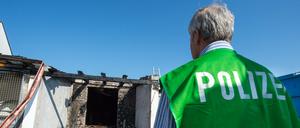 Ein Spurenermittler der Polizei steht am 16.07.2015 in Reichertshofen (Bayern) vor einem ehemaligen Landgasthof, der in den frühen Morgenstunden in Brand geraten war. Unbekannte haben in der Nacht zum Freitag einen Brandanschlag auf eine Asylbewerberunterkunft in der Oberpfalz verübt. 