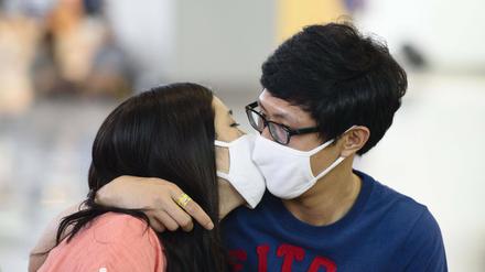 Dieses Pärchen in Busan küsst sich vorerst sicherheitshalber mit Gesichtsmaske. Die Menschen in Südkorea haben Angst vor dem Mers-Virus. Insgesamt sechs Tote und 87 Infektionen sind inzwischen im Land erfasst.
